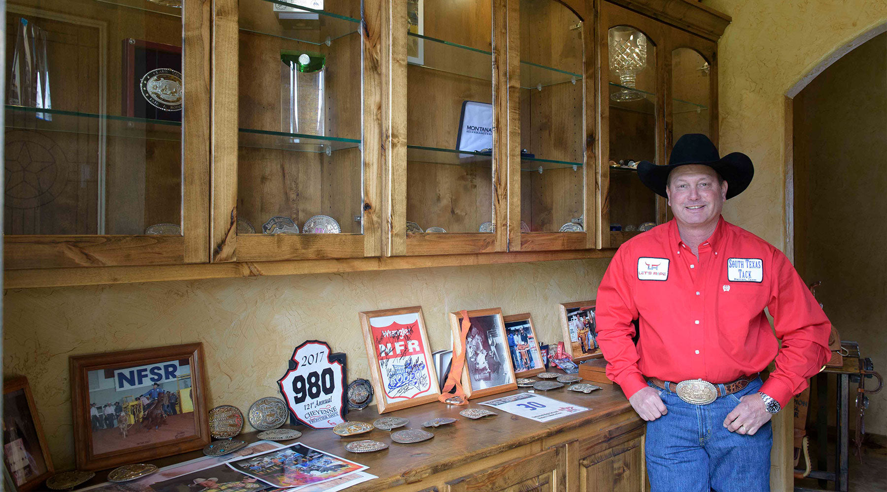 Rich Skelton standing with his back numbers and awards